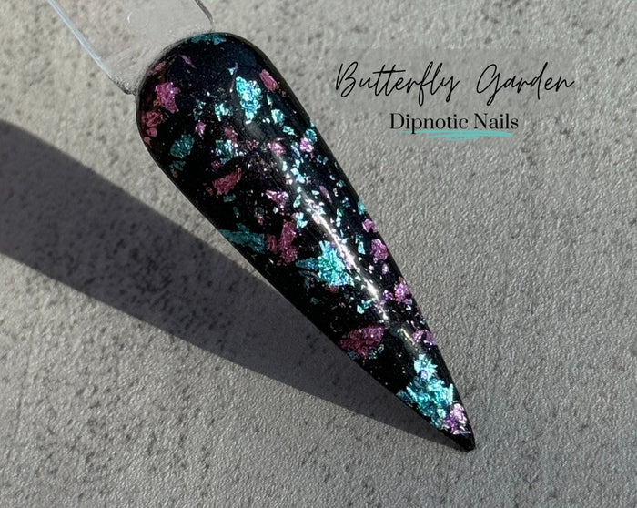 Photo shows swatch of Dipnotic Nails Butterfly Garden Black, Purple, and Blue Foil Nail Dip Powder The Butterfly Effect Collection