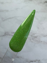 Photo shows swatch of Dipnotic Nails Cancer Green Nail Dip Powder Stardust Collection