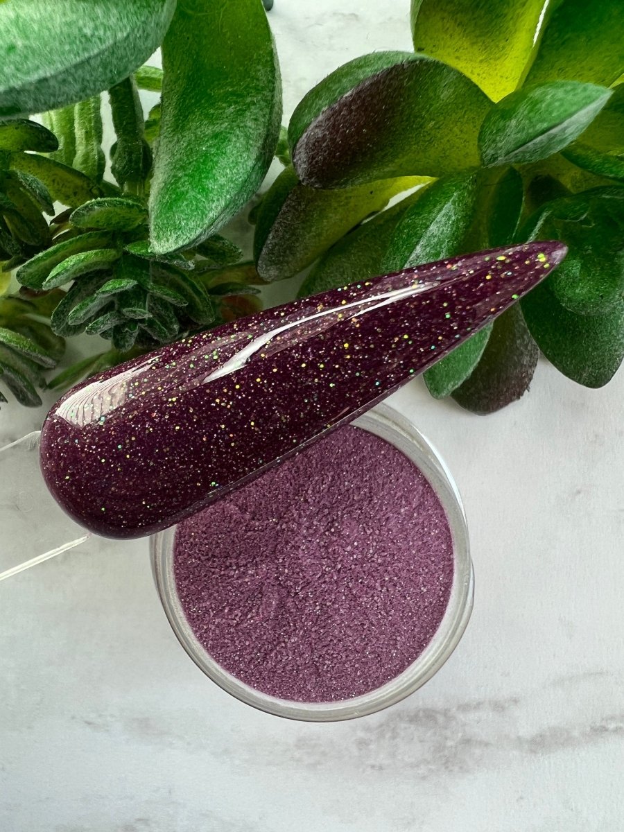 Photo shows swatch of Dipnotic Nails Capricorn Plum Nail Dip Powder Stardust Collection