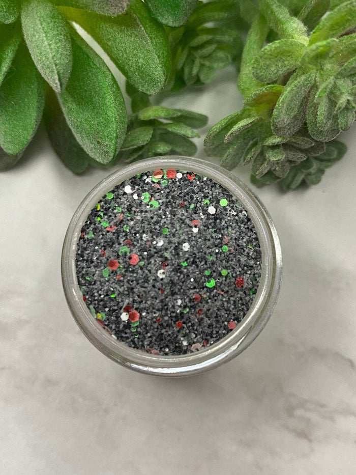 Photo shows swatch of Dipnotic Nails Christmas Coal Black Red and Green Christmas Nail Dip Powder