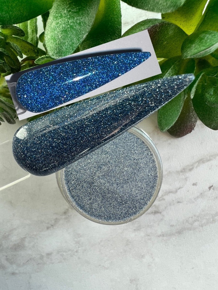 Photo shows swatch of Dipnotic Nails Echo Dark Blue Reflective Glitter Nail Dip Powder