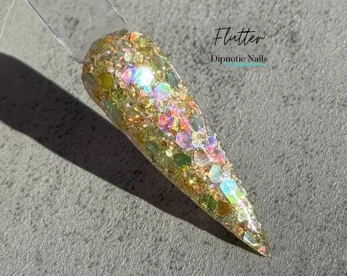 Photo shows swatch of Dipnotic Nails Flutter Yellow Holographic Nail Dip Powder The Butterfly Effect Collection