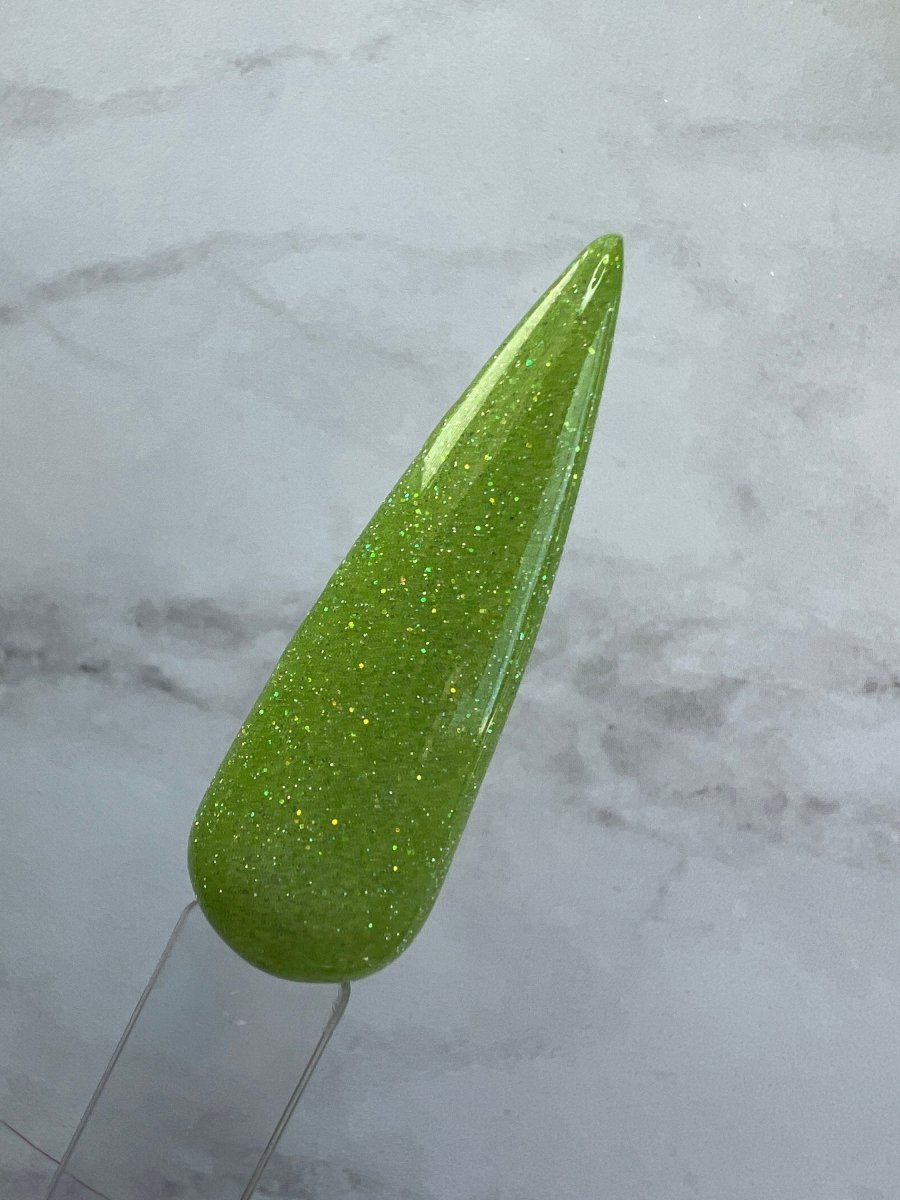 Photo shows swatch of Dipnotic Nails Gemini Green Nail Dip Powder Stardust Collection
