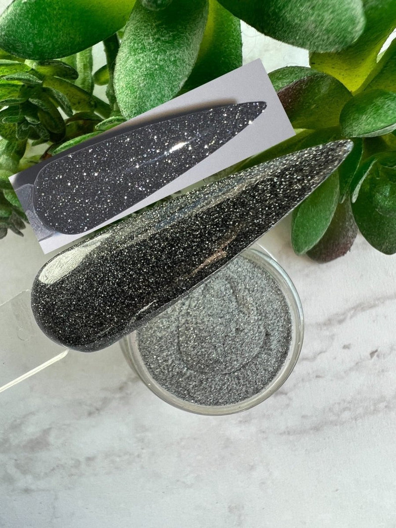 Photo shows swatch of Dipnotic Nails Impression Black Reflective Glitter Nail Dip Powder