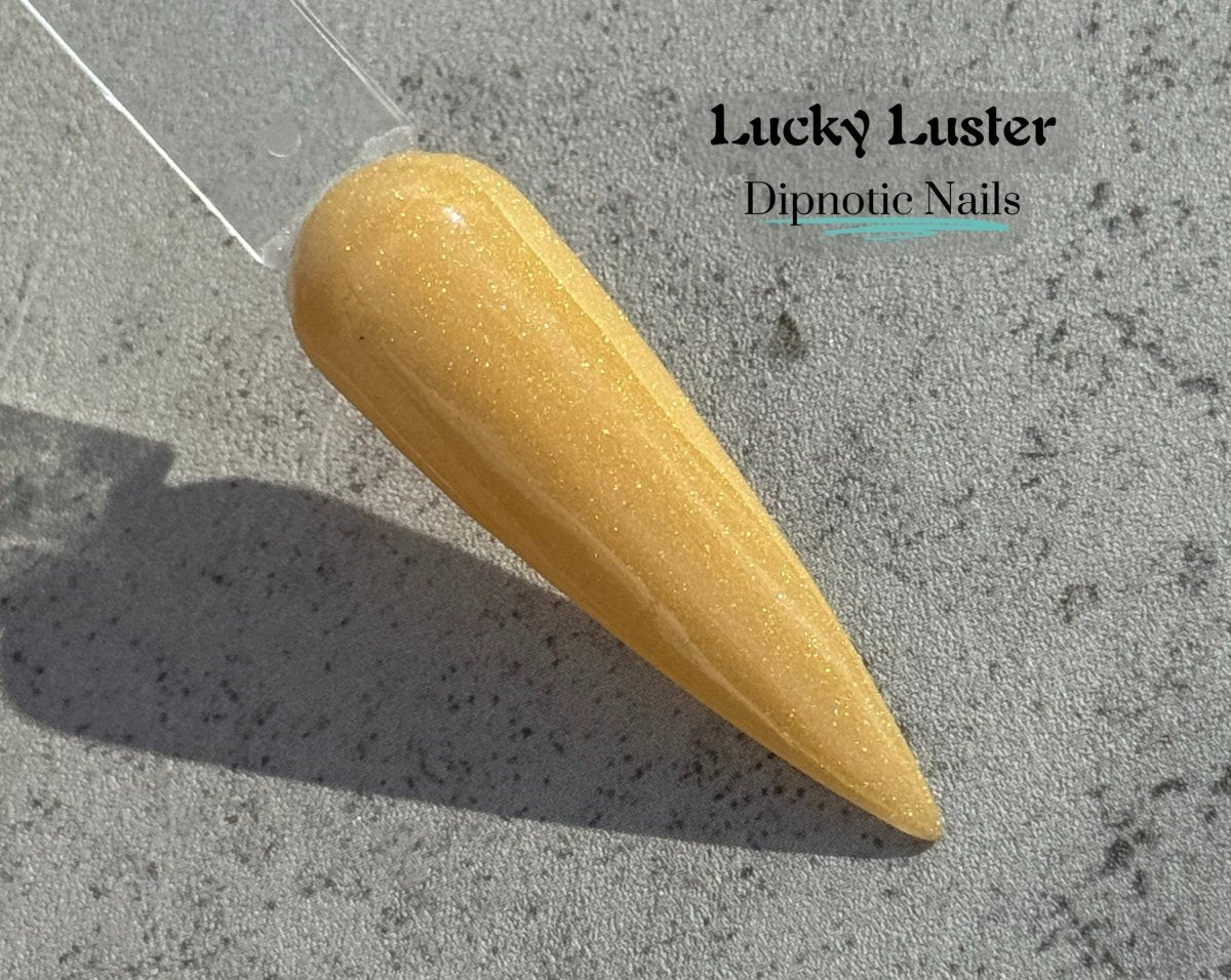 Photo shows swatch of Dipnotic Nails Lucky Luster Gold Nail Dip Powder The Dublin After Dark Collection