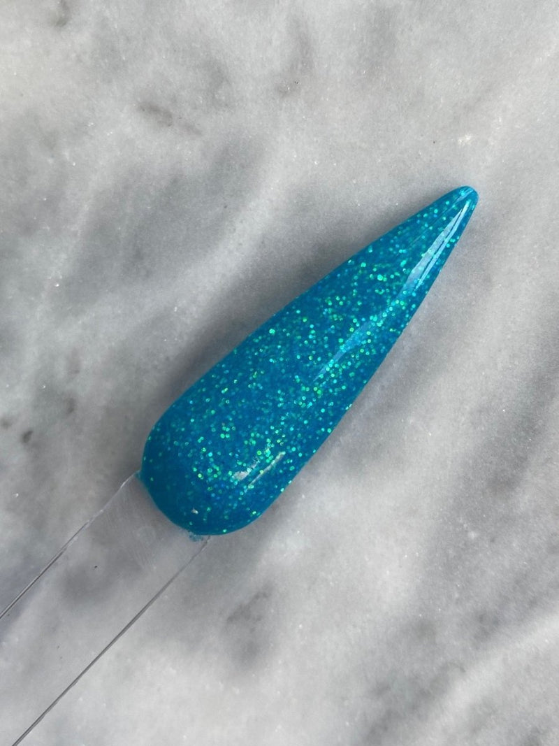 Photo shows swatch of Dipnotic Nails Luminescent Blue Nail Dip Powder