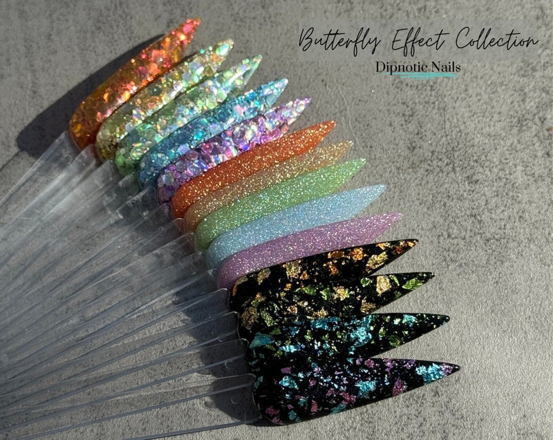 Photo shows swatch of Dipnotic Nails Metamorphosis Black, Gold, and Green Foil Nail Dip Powder The Butterfly Effect Collection