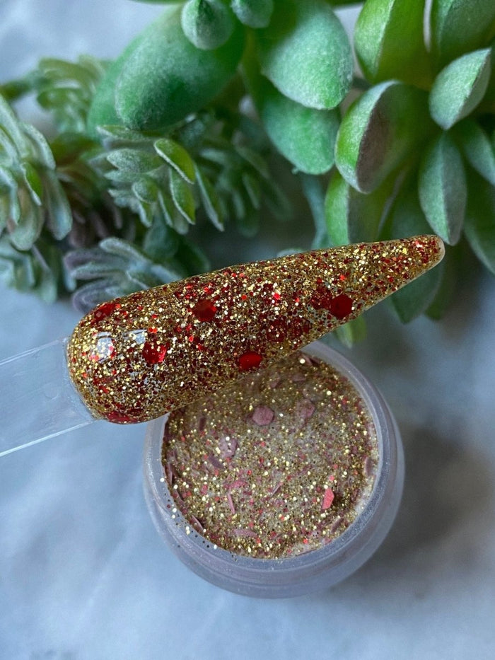 Photo shows swatch of Dipnotic Nails Nutcracker Gold and Red Christmas Nail Dip Powder