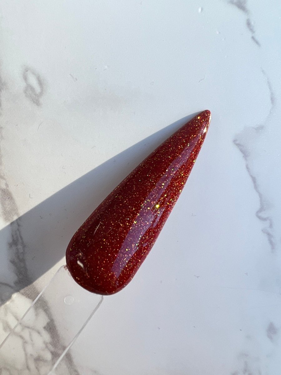 Photo shows swatch of Dipnotic Nails Perseus Red Nail Dip Powder Autumn Stardust Collection Expansion