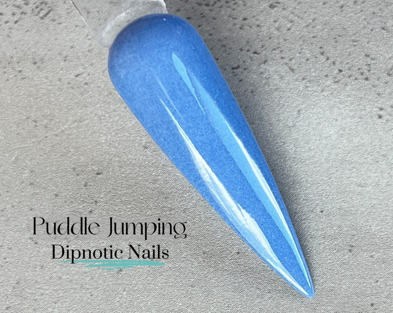 Photo shows swatch of Dipnotic Nails Puddle Jumping Periwinkle Blue Nail Dip Powder The April Showers and May Flowers Collection