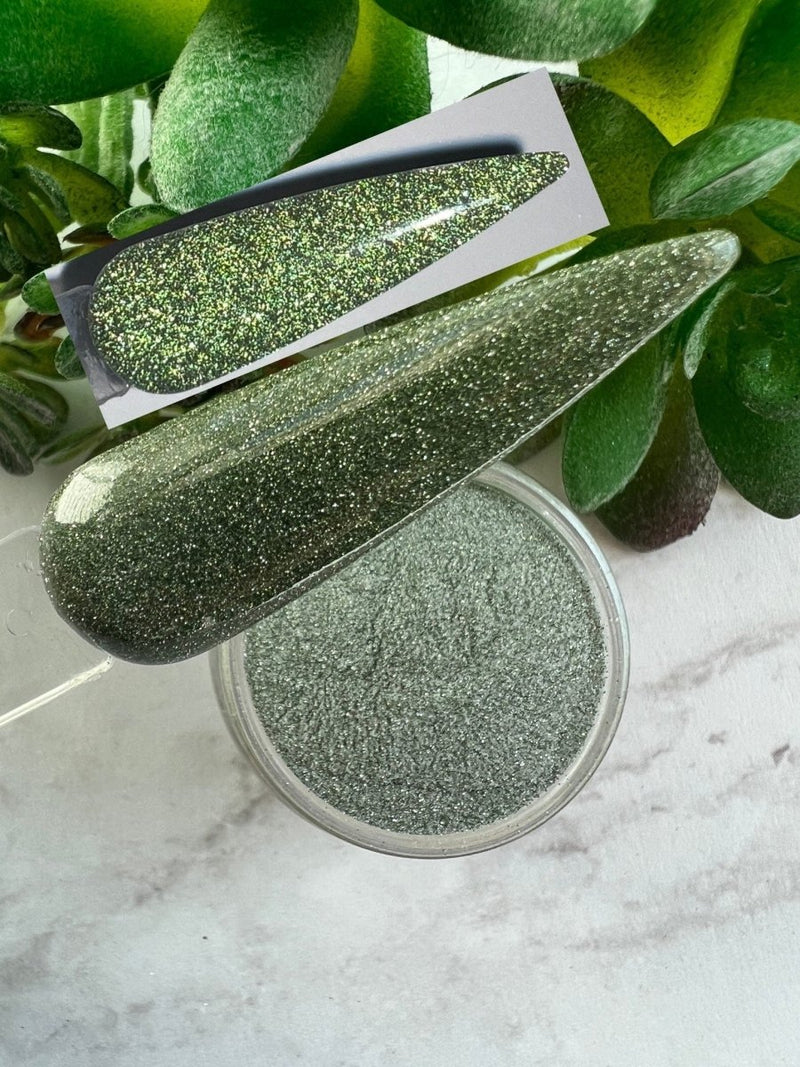 Photo shows swatch of Dipnotic Nails Repeat Light Green Reflective Glitter Nail Dip Powder