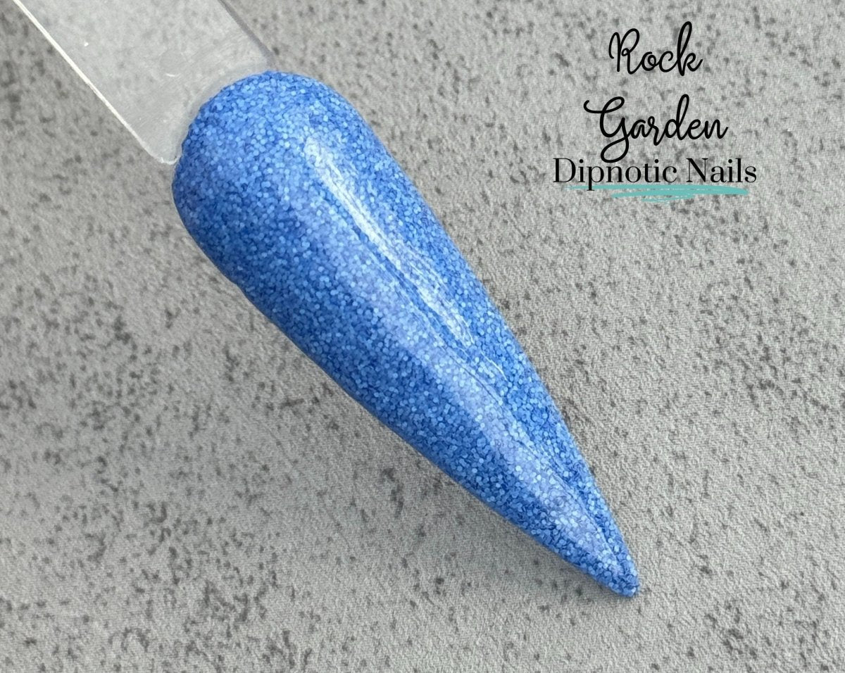 Photo shows swatch of Dipnotic Nails Rock Garden Periwinkle Dip Powder- The Enchanted Waters Collection