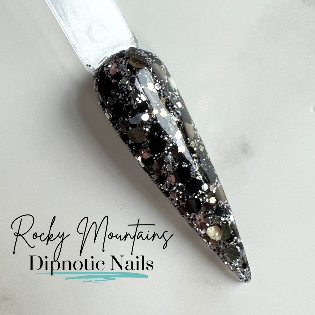 Photo shows swatch of Dipnotic Nails Rocky Mountains Black, Silver, and Gold Glitter Dip Powder The Colorado Winter Collection