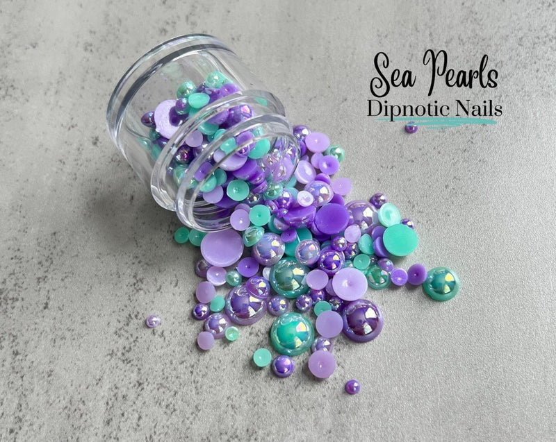 Photo shows swatch of Dipnotic Nails Sea Pearls Teal and Purple Flat Back Iridescent Pearls