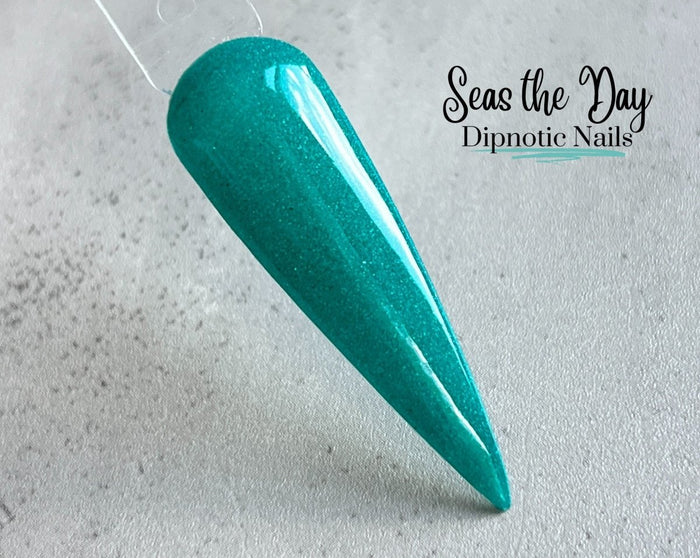 Photo shows swatch of Dipnotic Nails Seas the Day Dark Teal Blue Nail Dip Powder The Mermaid Magic Collection
