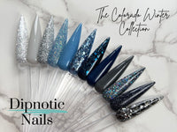 Photo shows swatch of Dipnotic Nails Telluride Navy Blue Glitter Dip Powder The Colorado Winter Collection